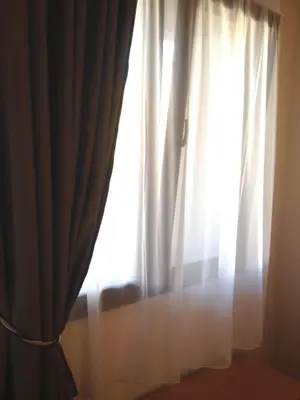 a window with white curtains in a room at Posto studio 3 Chania Crete 100m from the beach in Daratso
