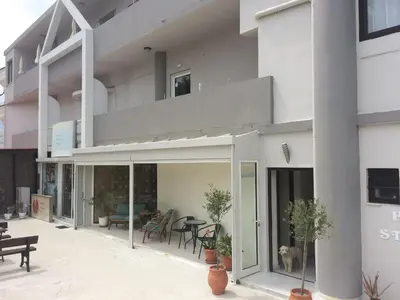 a building with a balcony with a dog on it at Posto studio 3 Chania Crete 100m from the beach in Daratso