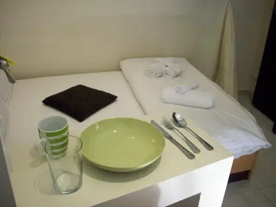 a table with a green bowl and a plate on it at Posto Studio 5 Chania Crete 100 m from the beach in Daratso