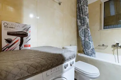 a small bathroom with a bed and a toilet at Ferenikis apartment in Chania Town