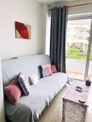 a couch in a living room with a window at Ferenikis apartment in Chania Town