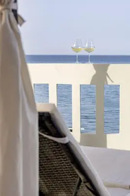 two glasses of wine sitting on a window sill at Beachfront luxury suite in Kalyves