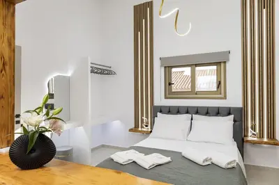 a bedroom with a bed with a table and a mirror at Beachfront luxury suite in Kalyves