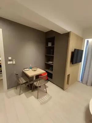 a dining room with a table and chairs and a tv at Sandy Suite 2 in Agia Marina Nea Kydonias