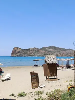 a beach with chairs and umbrellas and the ocean at Sandy Suite 2 in Agia Marina Nea Kydonias