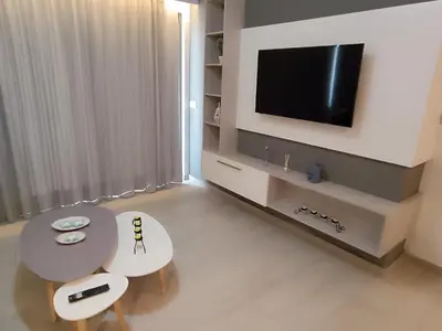 a living room with a table and a tv at Sandy Suite 3 in Agia Marina Nea Kydonias