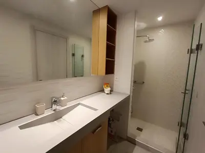 a bathroom with a sink and a shower with a mirror at Sandy Suite 3 in Agia Marina Nea Kydonias