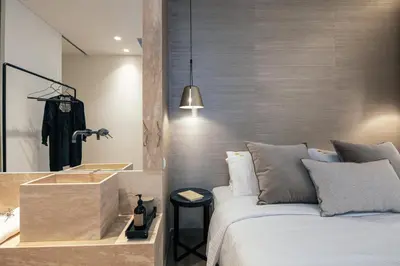 a bedroom with a bed and a bathroom with a sink at Sea Path II Chania city Center luxury Suites in Chania Town