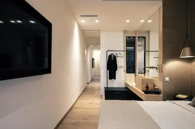 a bedroom with a large bed and a mirror at Sea Path II Chania city Center luxury Suites in Chania Town