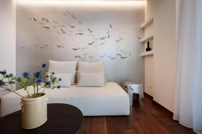a bedroom with a bed with birds on the wall at Sea Path III Chania city Center luxury Suites in Chania Town