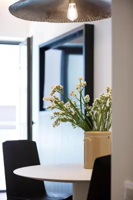 a table with a vase of flowers on top of it at Sea Path IV Chania city center luxury Appartment in Chania Town
