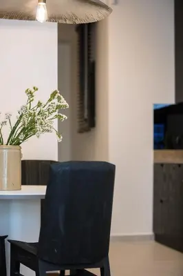 a black chair sitting next to a table with a potted plant at Sea Path IV Chania city center luxury Appartment in Chania Town