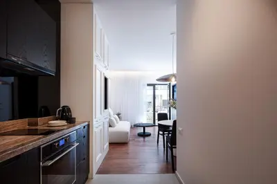 a kitchen with black cabinets and a dining room at Sea Path IV Chania city center luxury Appartment in Chania Town