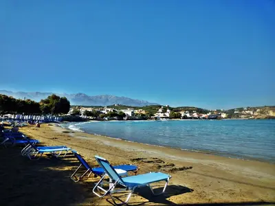 a group of lounge chairs on a beach at Heliopetra studios, small village near beaches in Douliana