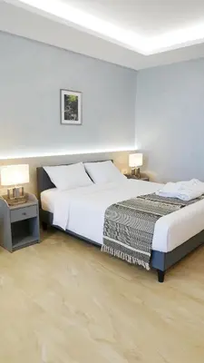 two beds in a hotel room with two lamps at Amour Relax Hotel in Almirida