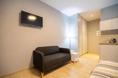 a living room with a chair and a tv on the wall at Amour Relax Hotel in Almirida
