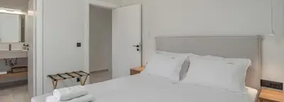 a bedroom with a white bed with white pillows at Nemia Luxury Residence in Chania Town