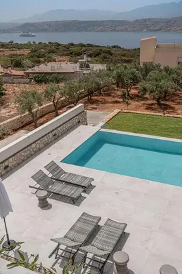 a swimming pool with chairs and a view of the ocean at Nemia Luxury Residence in Chania Town
