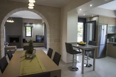 a dining room and kitchen with a table and chairs at Villa-Azalea in Almirida