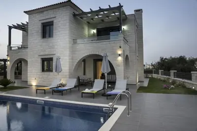 a house with a swimming pool next to a building at Villa-Azalea in Almirida