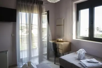 a bedroom with a bed and a sink and a mirror at Villa-Azalea in Almirida