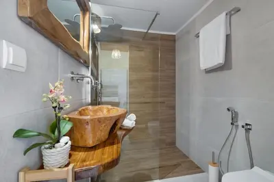 a bathroom with a wooden bowl sink and a shower at Maestro House in Chania Town
