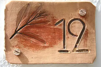 a bronze plaque with a leaf on it at Proimos Maisonnettes in Plataniás