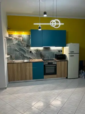 a kitchen with blue cabinets and a white refrigerator at Marias Apartment in Chania Town