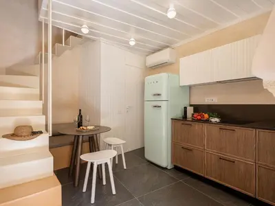 a kitchen with a refrigerator and a table and chairs at Monk Residence 27 - next to old Venetian Harbor in Chania Town