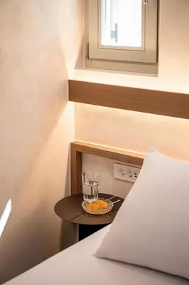 a small table with a glass on it next to a bed at Monk Residence 27 - next to old Venetian Harbor in Chania Town