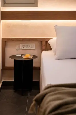 a hotel room with a bed and a table with a glass at Monk Residence 27 - next to old Venetian Harbor in Chania Town