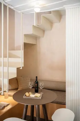 a table with two wine glasses and a staircase at Monk Residence 27 - next to old Venetian Harbor in Chania Town