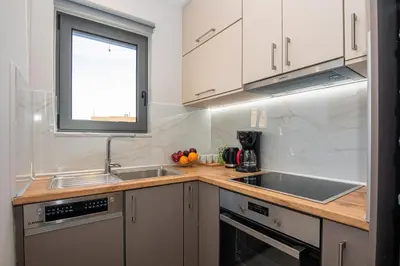 a kitchen with white cabinets and a sink and a window at Filitsa's Luxury House in Chania Town