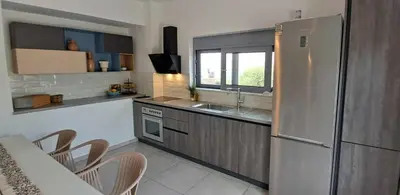 a kitchen with a refrigerator and a table and chairs at MariAdni Garden House in Kissamos