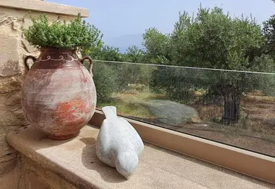 a vase and a small cat sitting on a window sill at MariAdni Garden House in Kissamos