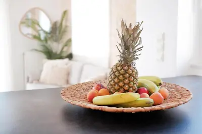 a plate of fruit on a table with a pineapple at Everlane Seaview Villa in Arménoi