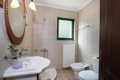 a bathroom with a sink and a toilet and a mirror at Jacuzzi Villa Nena in Thérison