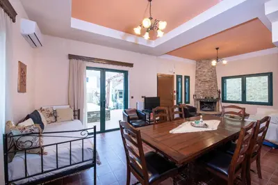 a dining room and living room with a table and chairs at Jacuzzi Villa Nena in Thérison