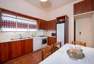 a kitchen with wooden cabinets and a table with a white counter top at Jacuzzi Villa Nena in Thérison