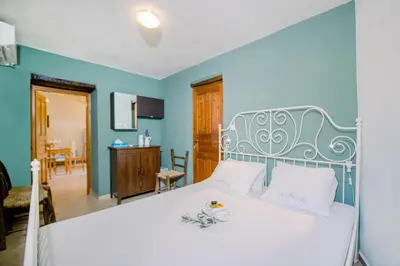 a bedroom with a white bed with a blue wall at Nature stone retreat between Balos & Elafonisi beach, contactless check-in, Mouri Nature House in Mouríon