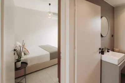 a bedroom with a bed and a sink and a mirror at Cozy Living Apartments Chania close to the beach in Chania Town