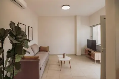 a living room with a couch and a tv at Cozy Living Apartments Chania close to the beach in Chania Town