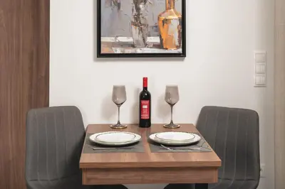 a wooden table with two chairs and a bottle of wine at The Sandgate Elegant studio, Chania Seaside in Chania Town