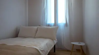 a bed with white sheets and a window in a room at Τhemis House in Chania Town