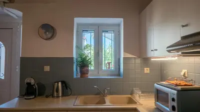 a kitchen with a sink and a window at Τhemis House in Chania Town