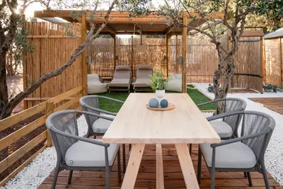 a patio with a wooden table and chairs at Falasarna Caravans in Falasarna