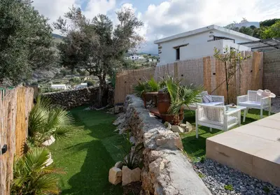 a garden with a fence and a table and chairs at Iasmos in Sfakiá