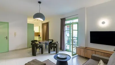 a living room with a table and chairs and a tv at Paleochora Central Apartments in Palaiochóra