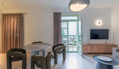 a living room with a table and chairs and a television at Paleochora Central Apartments in Palaiochóra