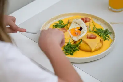a person eating a bowl of food with an egg on top at SugarDustApt Elegant Retreat 150m from the Sea in Chania Town